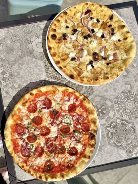 Dwie autorskie pizze na stole w bistro Gronostajowa 7