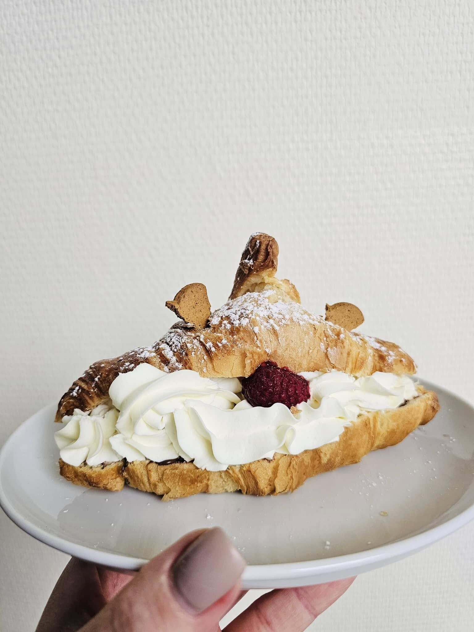 Croissant z kremem i maliną na talerzu