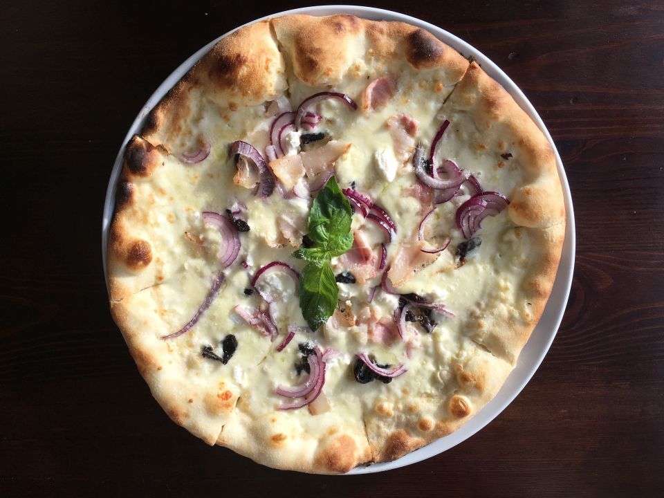 Pizza na białym sosie z czerwoną cebulą, boczkiem i bazylią